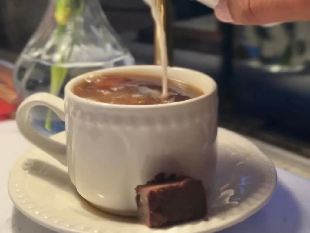 Cream being poured into a coffee cup aboard The Charnwood Forester