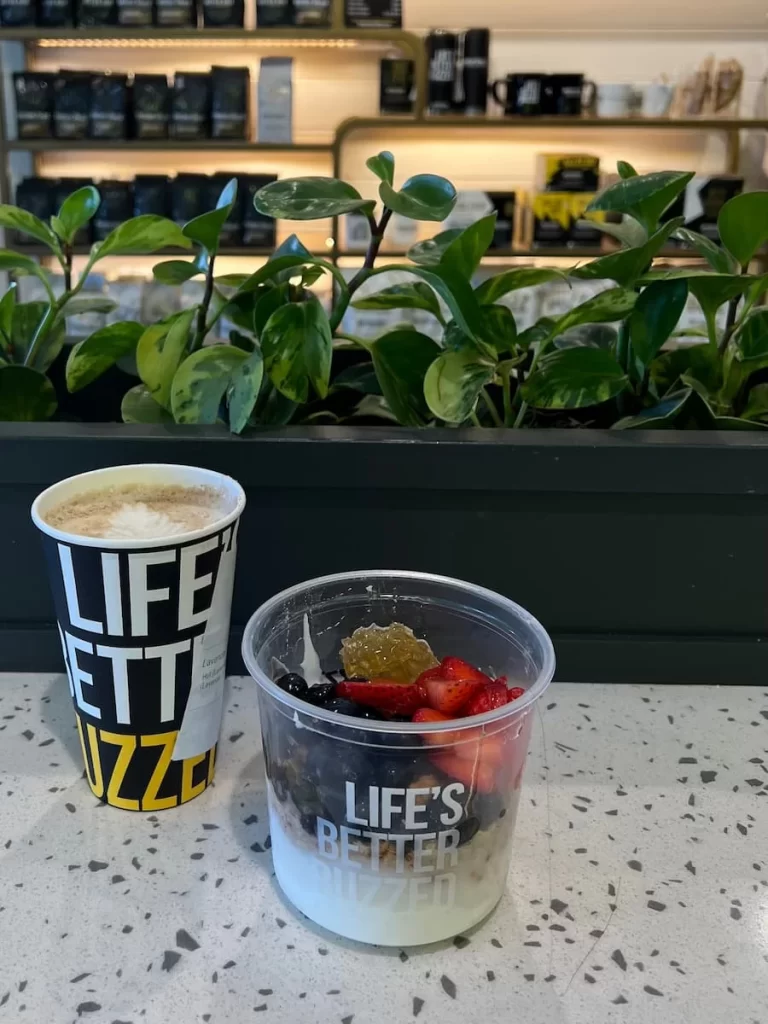 Better Buzz Coffee, Coronado with a lavender tea latte and fruit and yoghurt bowl. There are plants in the background.