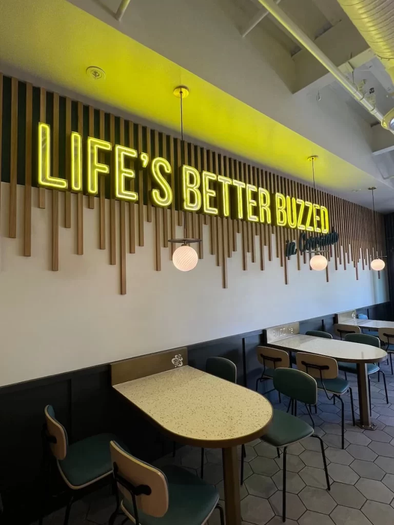 Better Buzz Coffee interiors with bright yellow signage, tables and chairs in Coronado