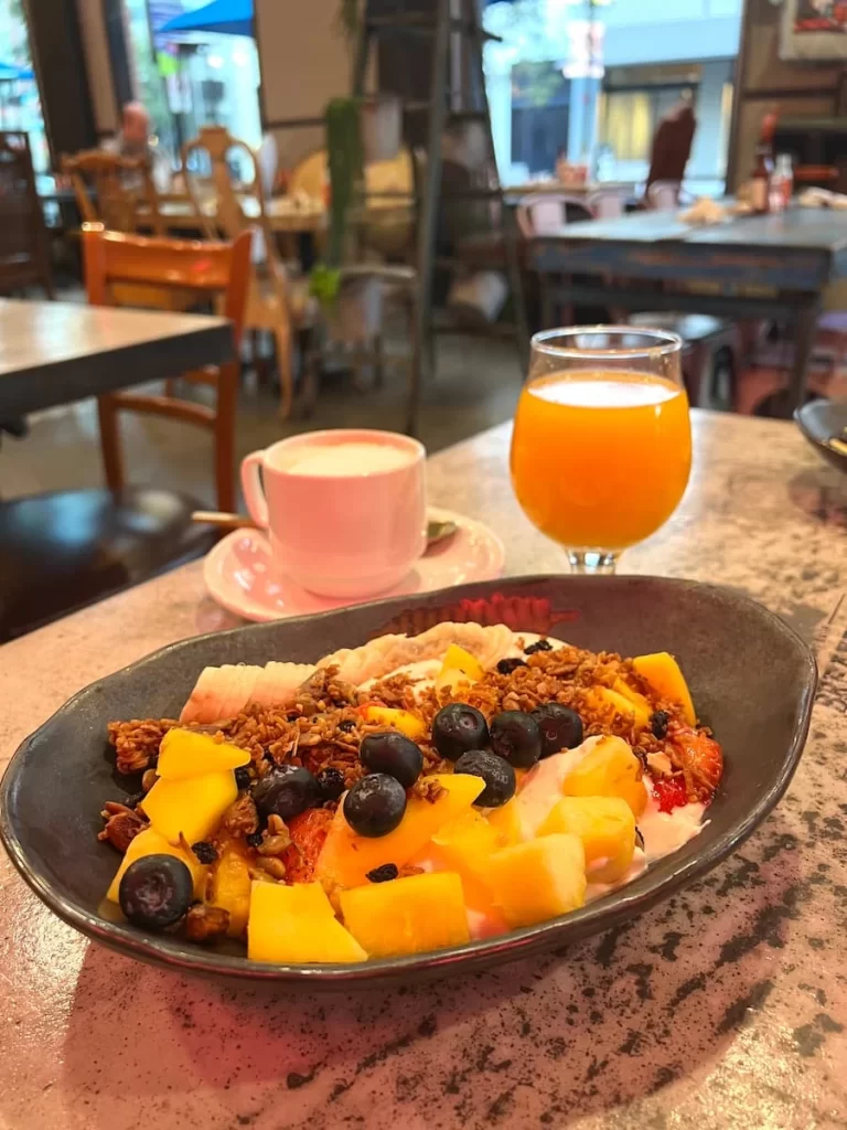 Fruit bowl with fruit, yoghurt and granola with orange juice and a latte at Gaslamp Breakfast Company, San Diego