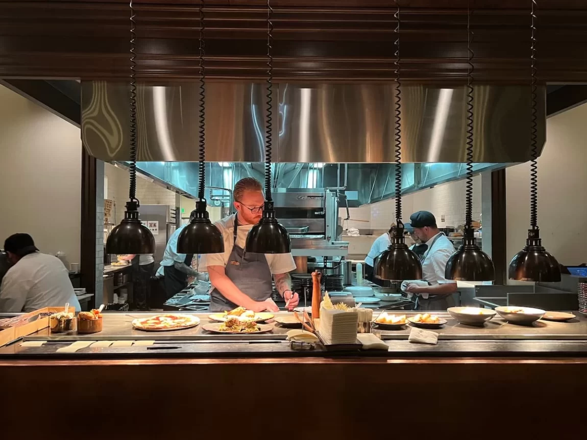 Open kitchen with chef checking plates at Provisional Kitchen, San Diego