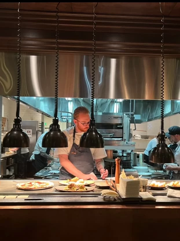 Open kitchen with chef preparing dishes at Provisional Kitchen, San Diego