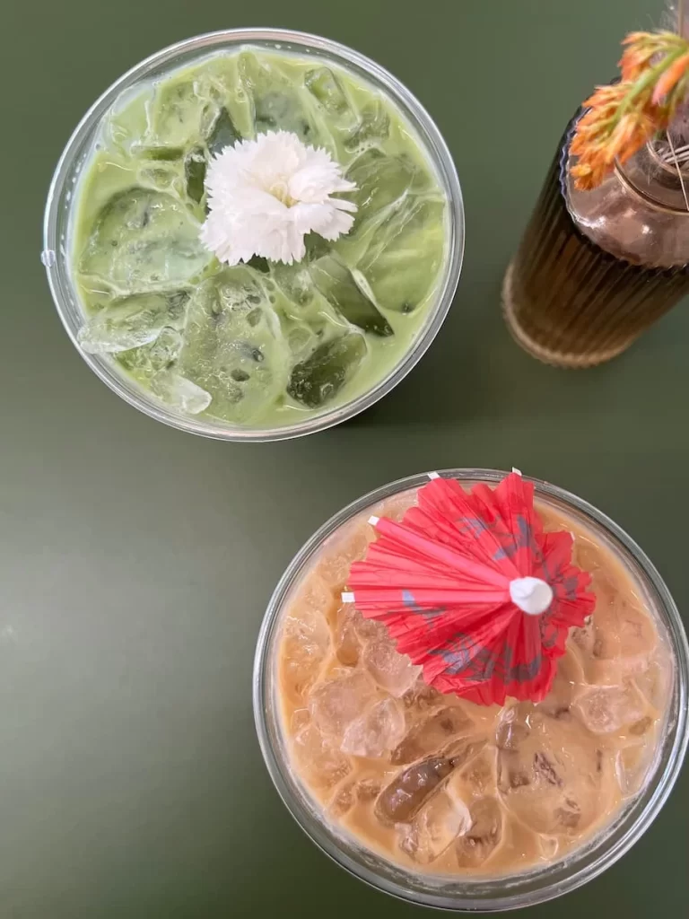 Evergreen (iced - local mint, vanilla, espresso and milk) & Hanalei Bae iced - pineapple, rum infused maple syrup, coconut, espresso and milk) top lay at Lovesong Coffee, North Park, San Diego