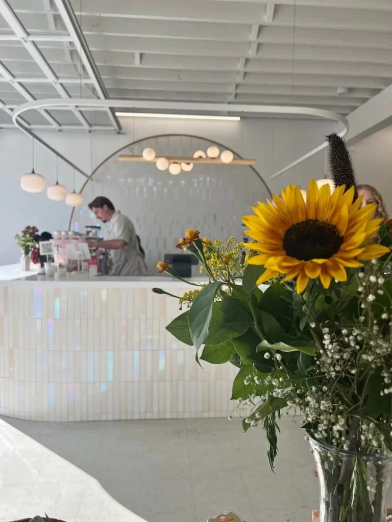 The coffee bar and interiors with sunflowers at Lovesong Coffee, North Park, San Diego