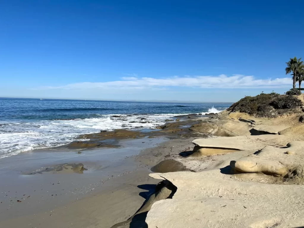 Rugged coastline of La Jolla beach with blue skies and bluffs