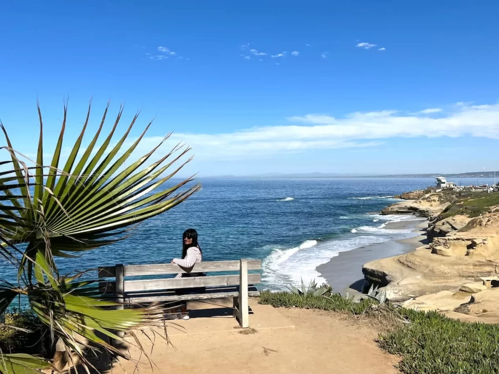 Bejal sitting on a bench relaxing at Loa Jolla beach 
