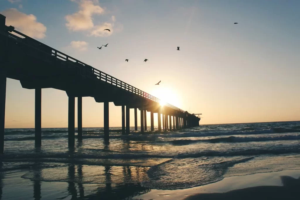 Scripps Pier at La Jolla at sunset with waves crashing the bottom of the pier