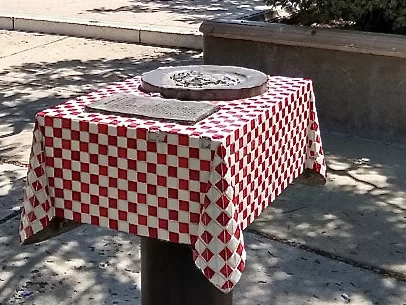 Checked red and white tablecloth with plaque and recipe at Amici Park, Little Italy, San Diego