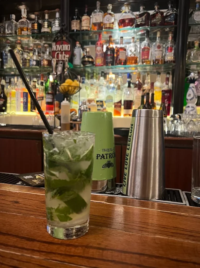 A mojito with straw against the bar front at Havana Grill, where they serve, vegetarian-friendly food in Chicago