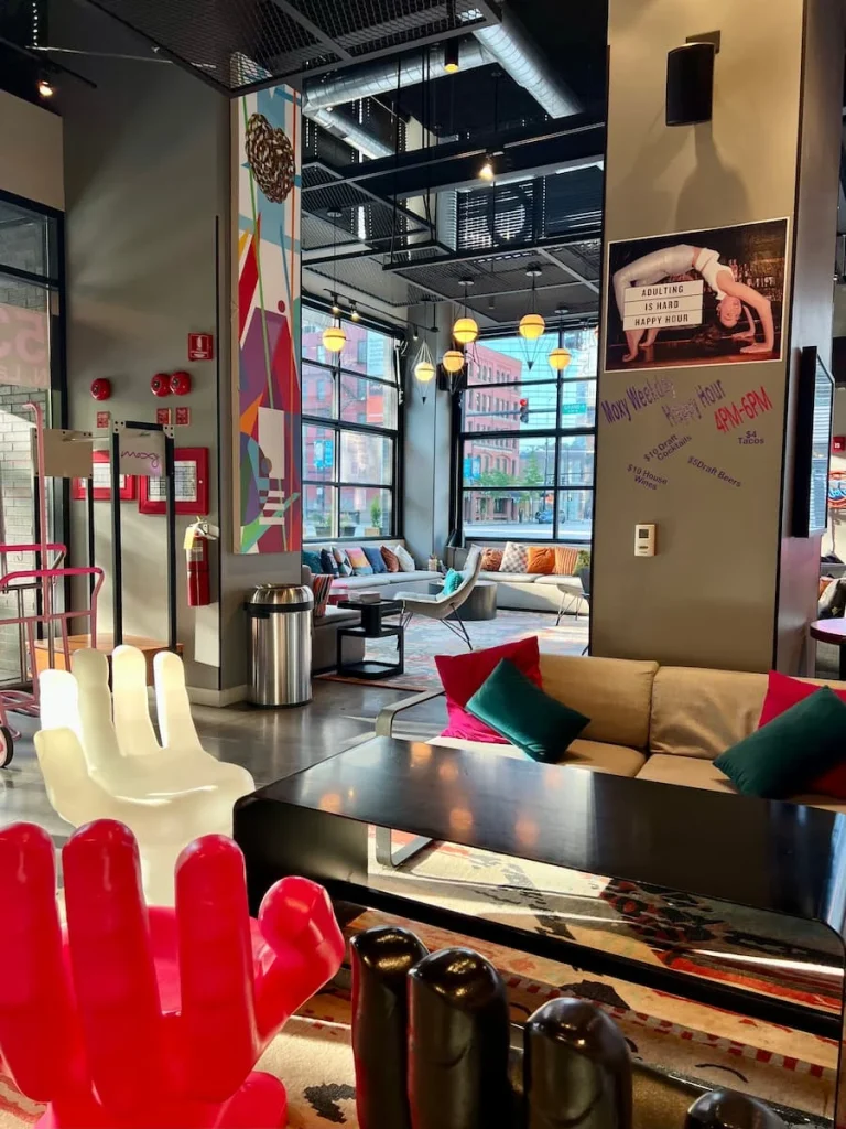 Alternate views of lounge area at Moxy, Chicago and colourful hand shaped seating chairs.