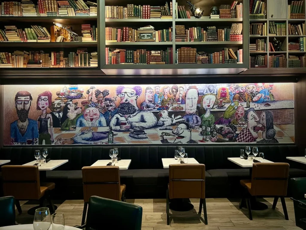 Artwork on the walls on a string of table seating at The Albert Restaurant in Chicago at The Hotel EMC2.one of the places that serves vegetarian friendly food in Chicago