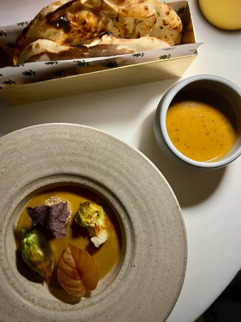 Close-up flat lay of vegetable kadai with garlic naan at Indienne, Chicago