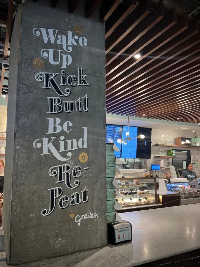 Cool store sign on a grey board at Goddess & Baker in Streeterville, Chicago with the service counter in the background. One of the best vegetarian friendly food in Chicago