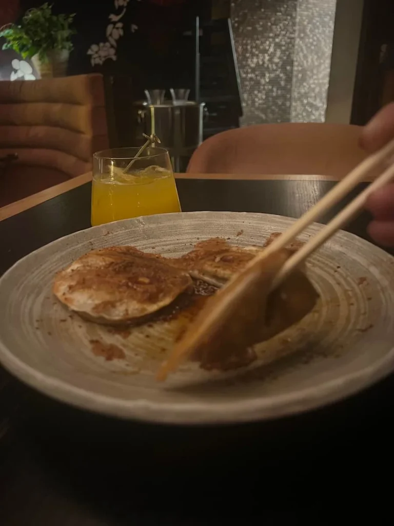 bejal picking up Crispy Gyoza from a plate with chopsticks at PLANTA, Chicago