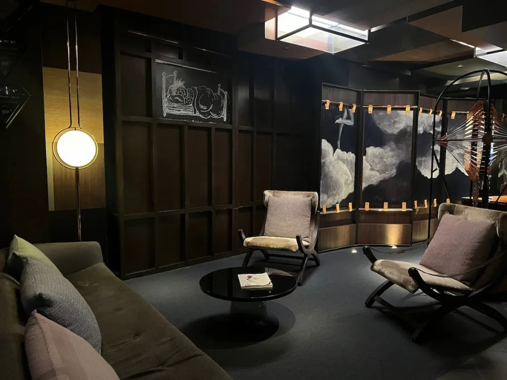 Seating area of the lobby with a armchairs and a long sofa at Hotel ECM2 with dark decor, one of the cool and quirky boutique hotels in Chicago