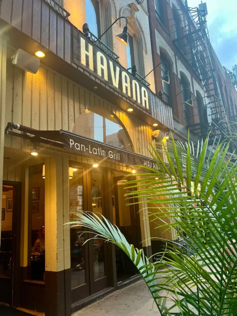 Exterior with long grass plants at the Havana Grill in Chicago. Big yellow letters reading Havana and a yellow building facade, vegetarian friendly food in Chicago