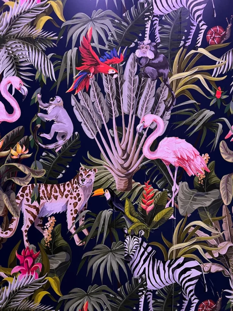 Flamingo and leopard wallpaper in lifts at Moxy, Chicago with monkeys and jungle foliage against a black background