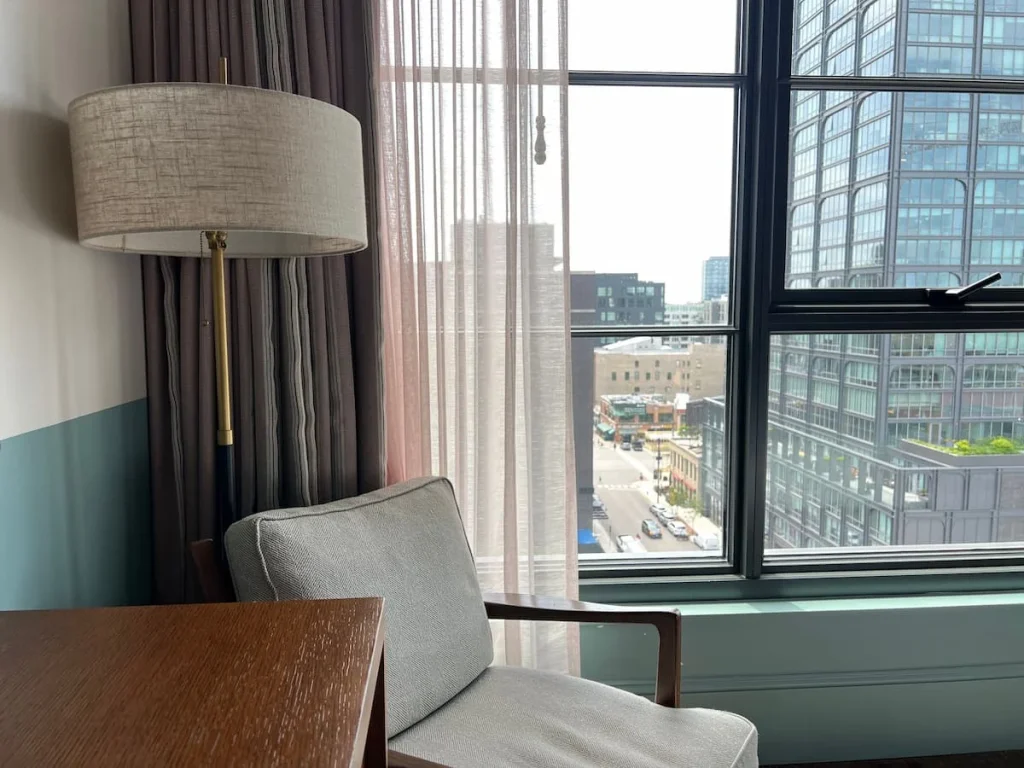 Guest room comfy chair with city views at The Hoxton, Chicago