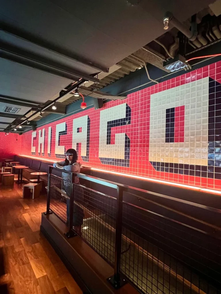 Bejal standing outside the Chicago sign at the TimeOut Market in Chicago