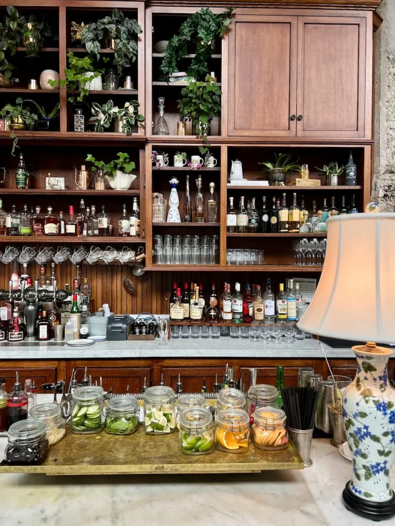 Bar area at Allis at Soho House, Chicago with drinks bottle, foligae and lamp.