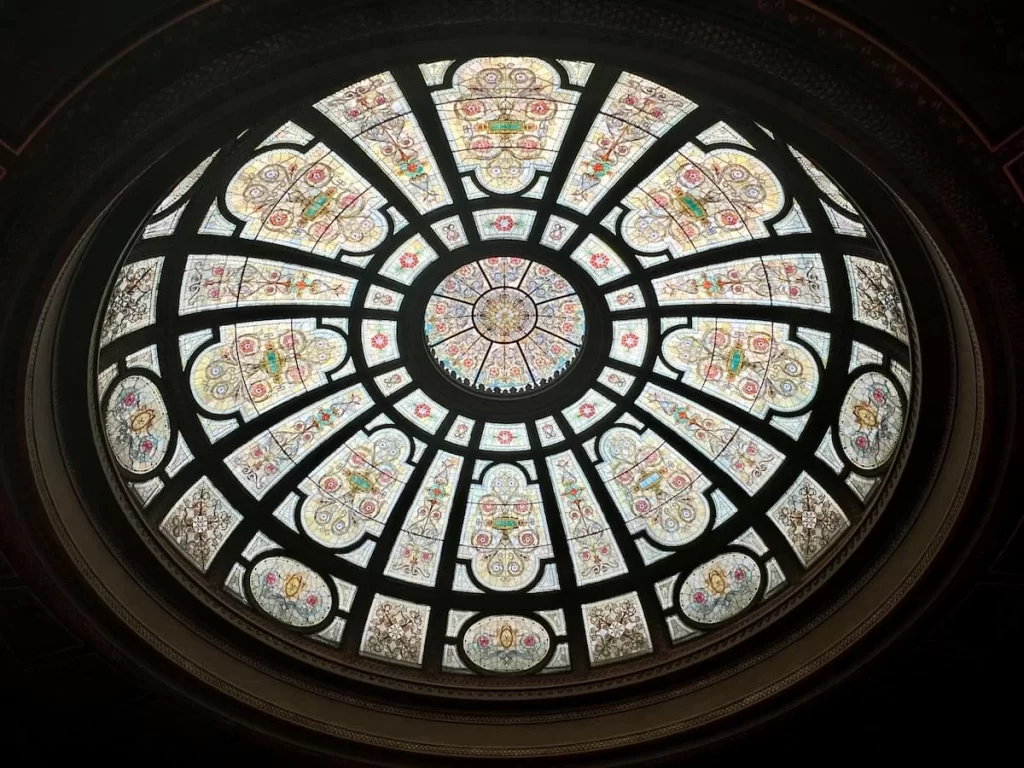 The Grand Army Of The Republic Rotunda Stained glass dome and a darkened ceiling around it. one of the non touristy things to do in Chicago