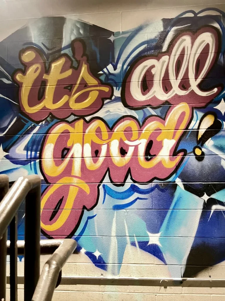 It's all good graffiti sign at Moxy, Chicago in red, yellow, blue and green lettering on a dark grey background