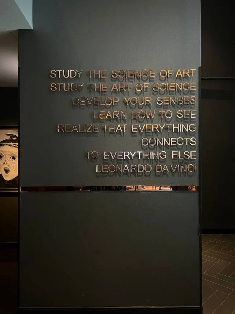 Leonarda da Vinci quote in gold lettering on dark grey wall in reception area of Hotel EMC2, one of the cool and quirky boutique hotels in Chicago