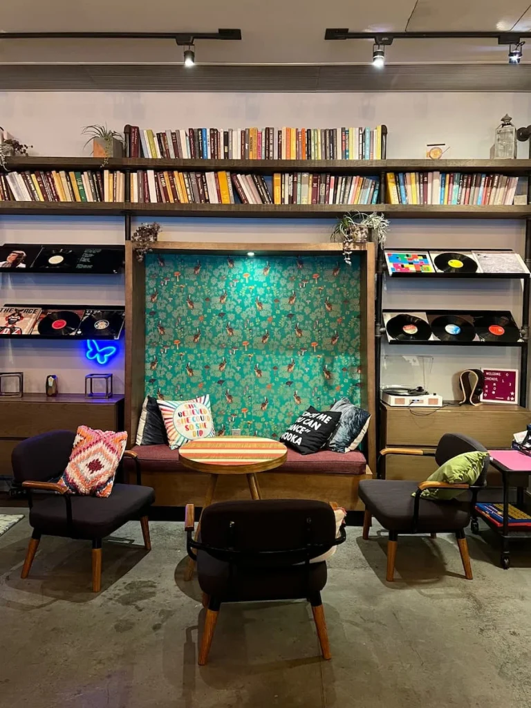 Lounging area and games in lobby at Moxy, Chicago with funky sofas, records and cushions on the back wall.