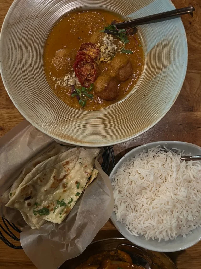 Malai Kofta top lay with naans and plain white rice at Kama, Chicago