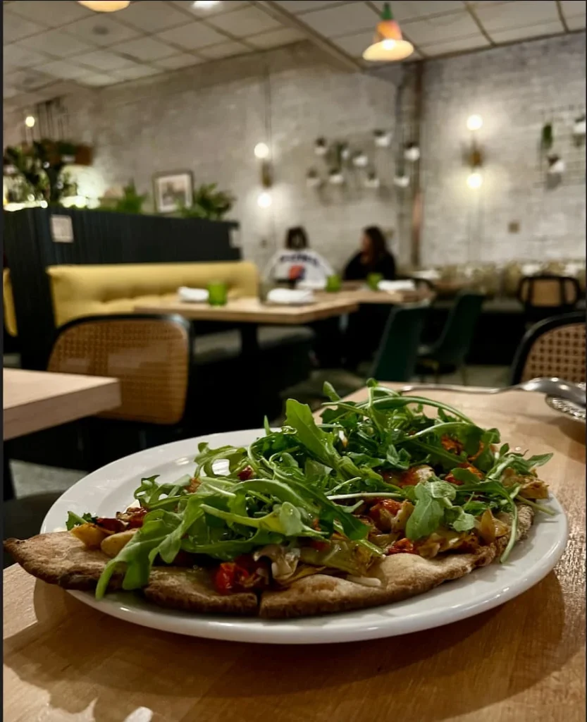 The half pizza with heirloom tomatoes, vinaigrette and rocket is a great side at Bloom plant-based Kitchen, Chicago