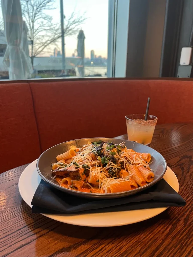 The Rigatoni Rosso and the spicy pineapple Fresno cocktail, at Lirica, Chicago. View of the Navy Pier in the Background
