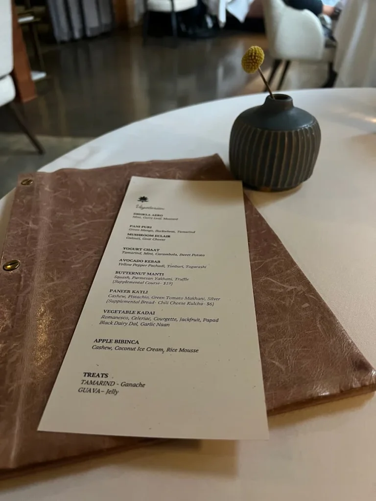 Vegetarian tasting menu at Indienne, Chicago on a salmon pink binder