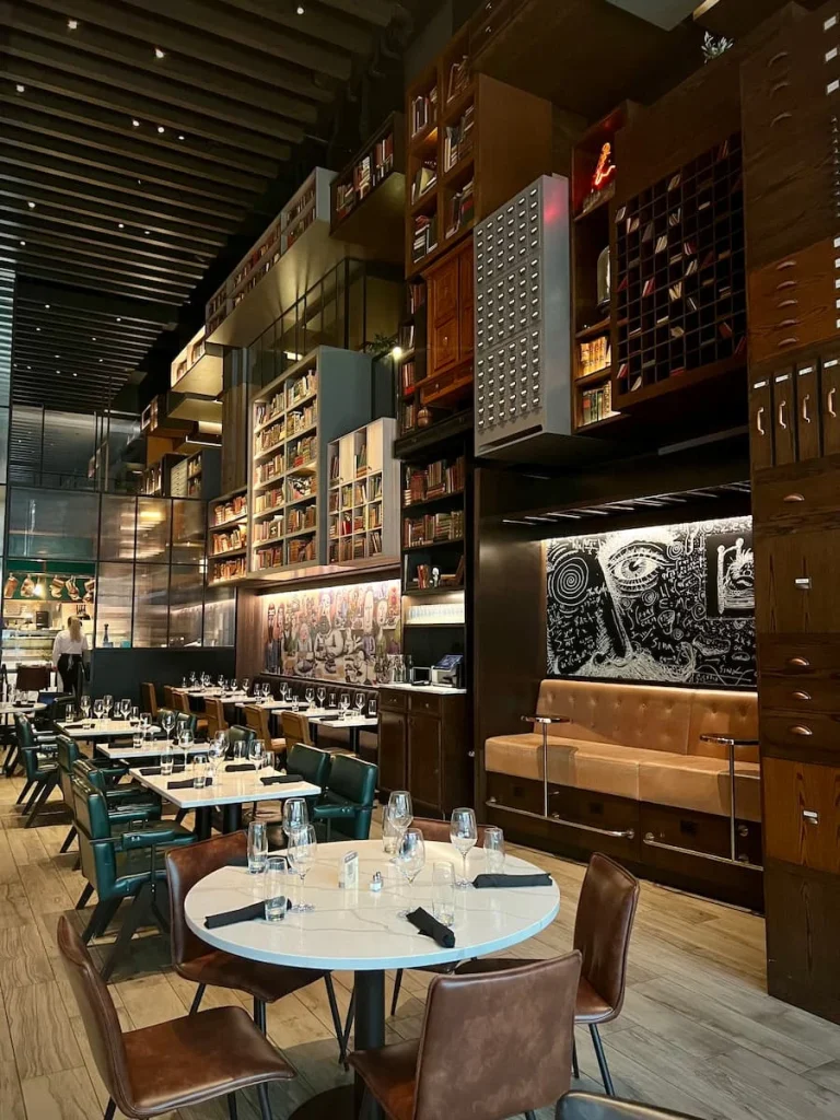 Side wall featuring dark woof door fascias and artwork in The Albert, Hotel EMC2, one of the places that serves vegetarian friendly food in Chicago