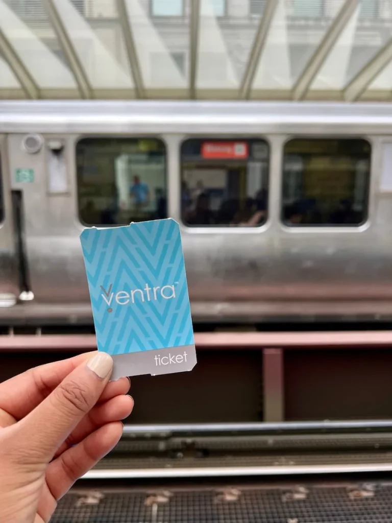 Pale blue Ventra ticket for the 'L' in Chicago with a train the background