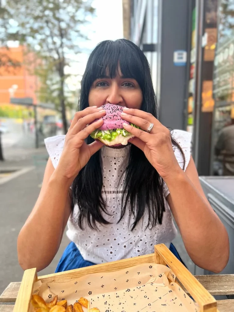 Bejal biting into a burger at Flower Burger, Marseille