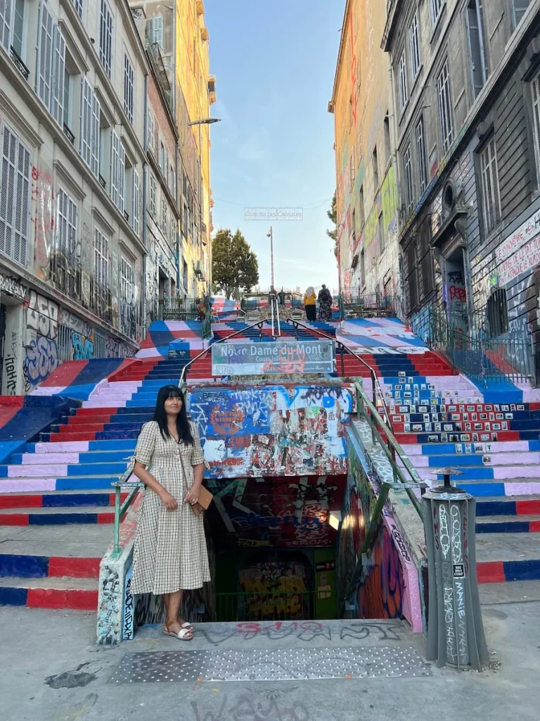 Bejal standing at the base of the graffiti Notre dame du Mont subway staircase, Marseille