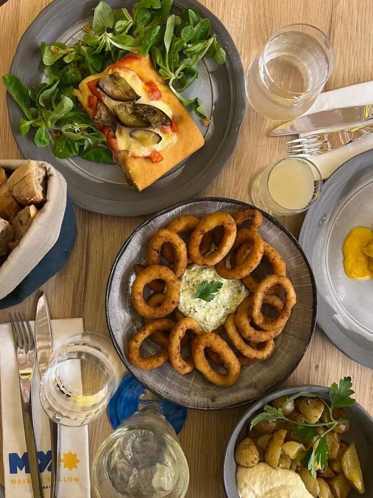 Top lay of the focaccia, onion rings, salad and other food at MX Maison Yellow Restaurant & Bar, Marseille