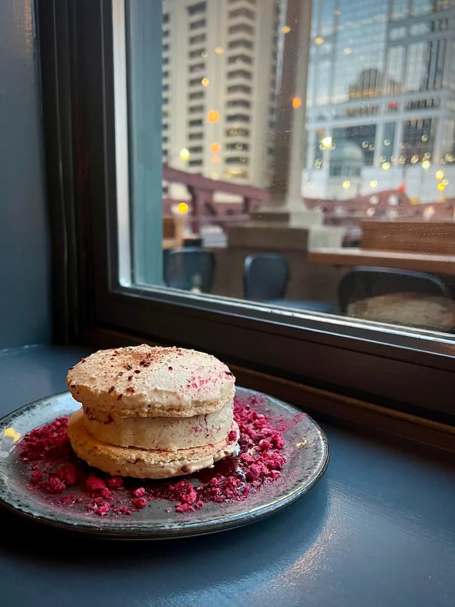 Ice-cream sandwich dessert at American Bistro, Chicago. Photo is franed by the window and grey ledge with the Chicago River and Well's Street Bridge in the background