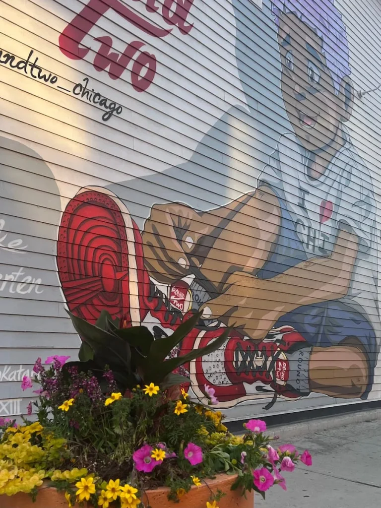 Street art of a boy tieing his shoe laces on a lined wall down on of the streets in Wicker Park, Chicago
