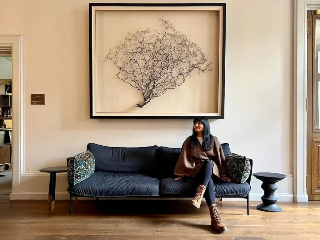 Bejal sat on sofa in hallway at Hampton Manor