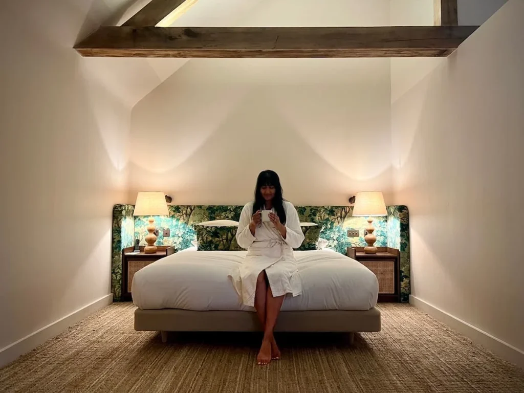 Bejal sitting on bed in Bed in the Coppicer Suite at Grave & Savour, Hampton Manor
