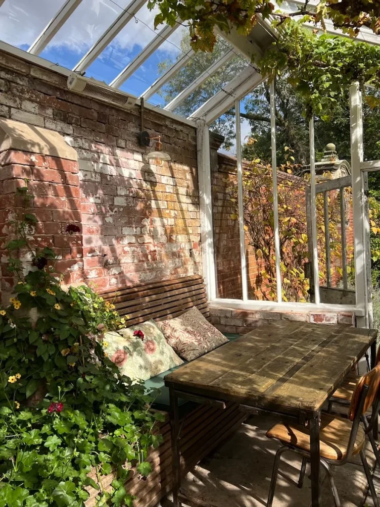 The greenhouse interior with cushioned seats and plants at Hampton Manor
