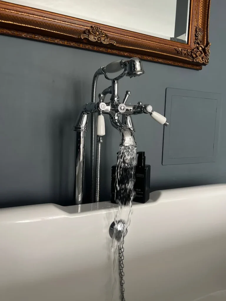 Bath taps with water running in Superior room at St Martins Lodge, Leicester
