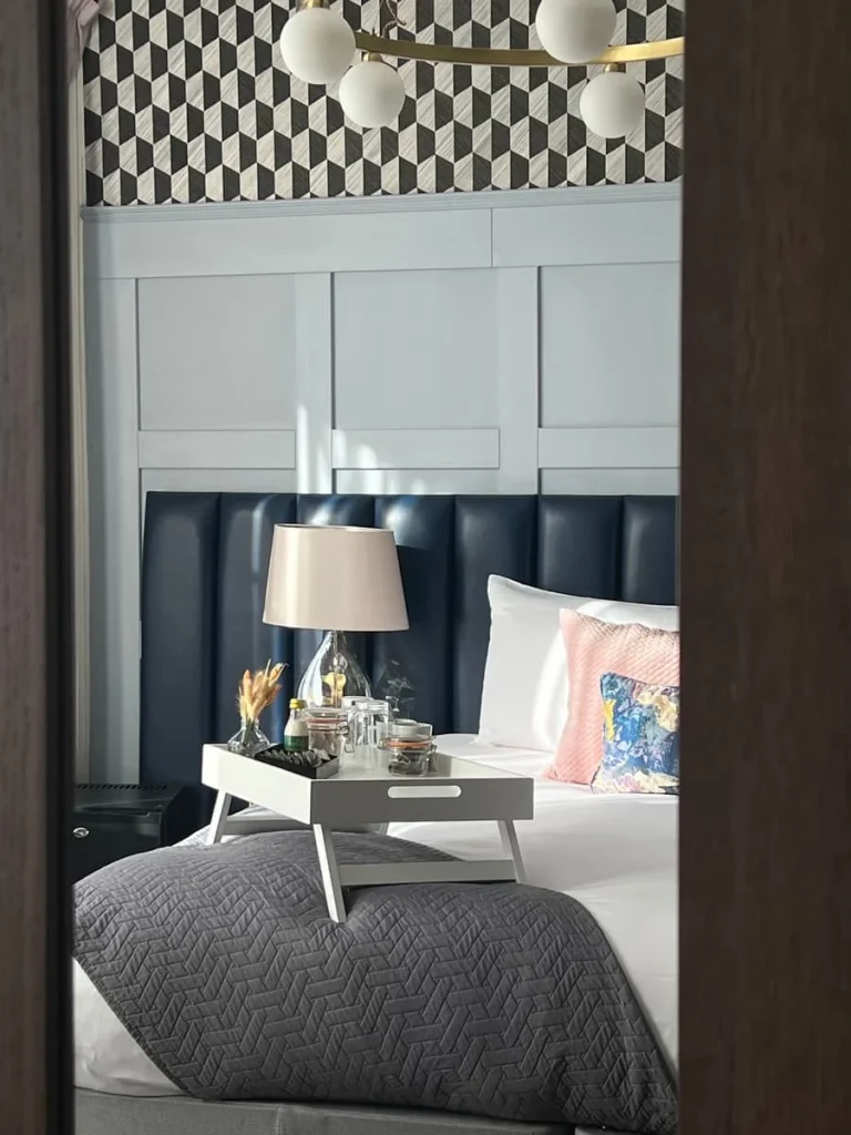 Reflection in wardrobe mirror of cushions, headboard and lamp close-up on bed in superior double room at St Martins Lodge, Leicester