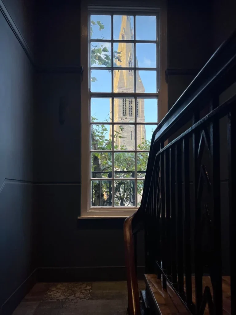 Long front window with view of Leicester Cathedral spire at St Martins Lodge, Leicester