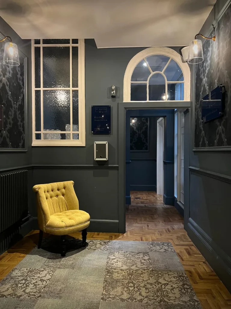 Hallway with gold/yellow chair at St Martins Lodge, Leicester