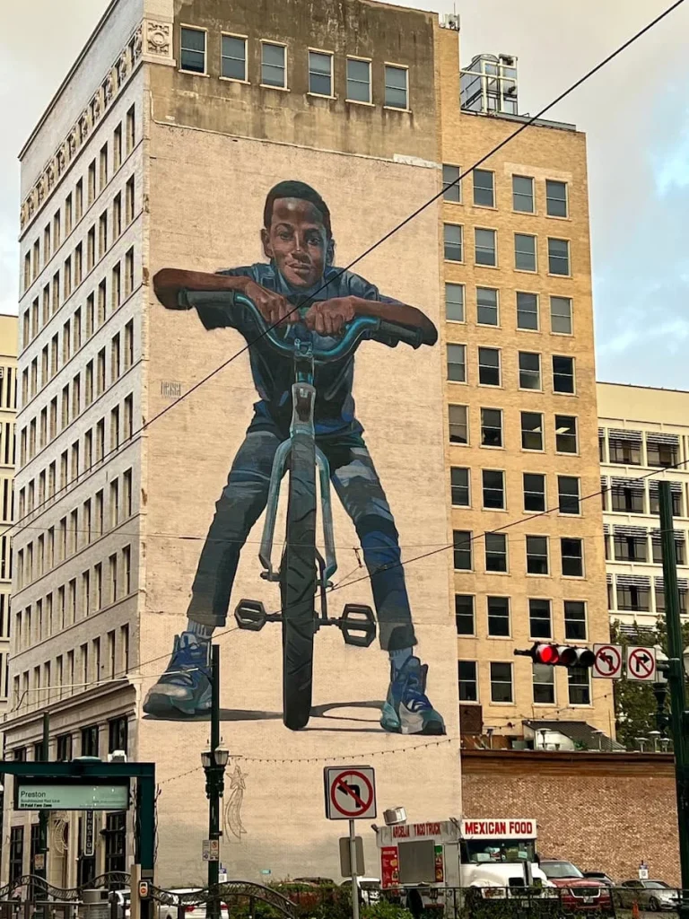 3 days in Houston: Mural Tour of boy on a bike overlooking the train coming in