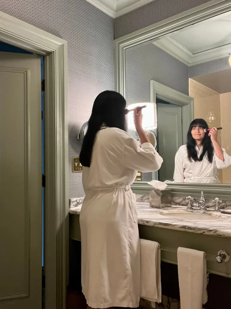 Bejal putting on make-up in bathroom at Hotel Icon, Houston