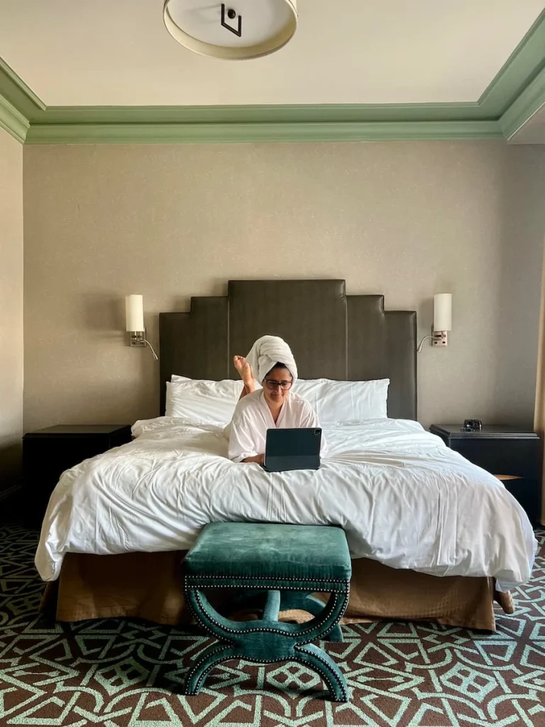 Bejal in bed with laptop in Hotel Icon room, Houston