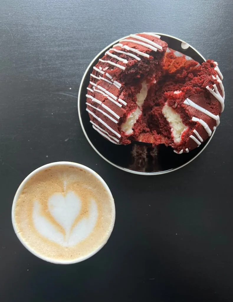 Red velvet muffin and cappuccino top lay at Slow Drip, Houston